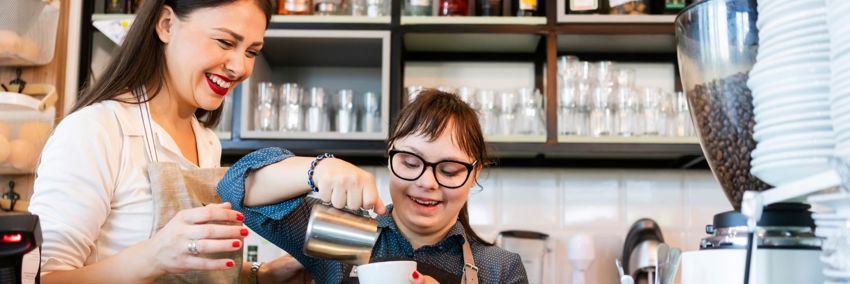 A Barista with Down's Syndrome is being trained on the job.