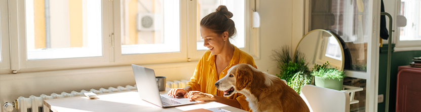 Woman working at home next to her dog